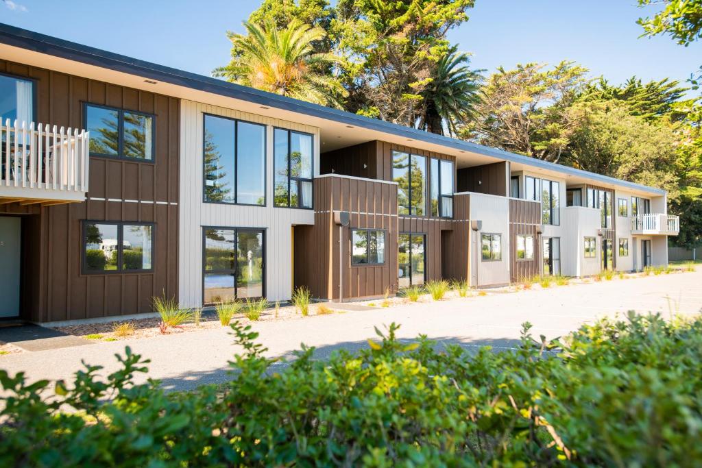 an exterior view of a building with trees at Waikanae Beach Ocean View Apartments in Gisborne