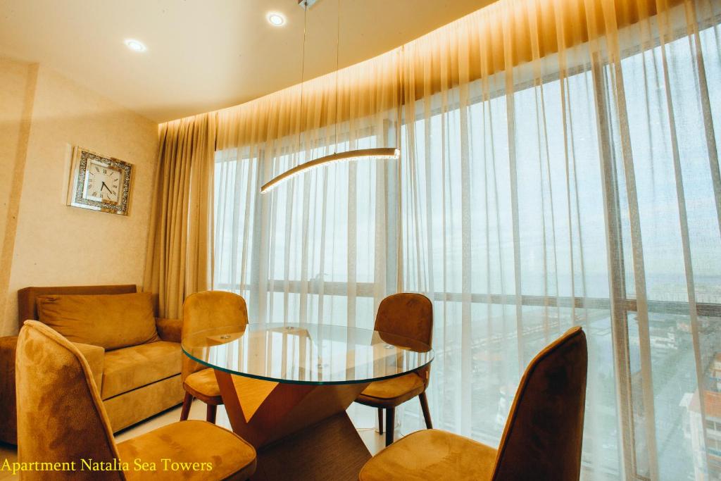 a dining room with a glass table and chairs at Blue Star Batumi in Batumi