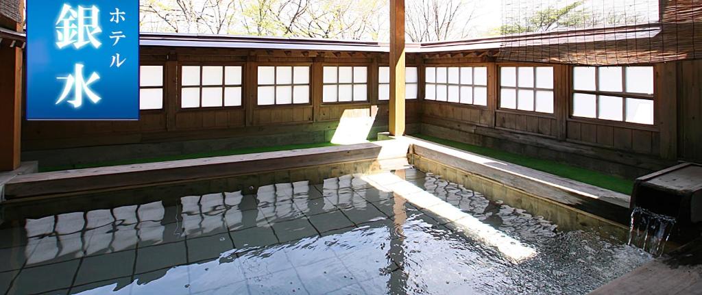 een tempel met een zwembad van water in een gebouw bij Hotel Ikaho Ginsui in Shibukawa