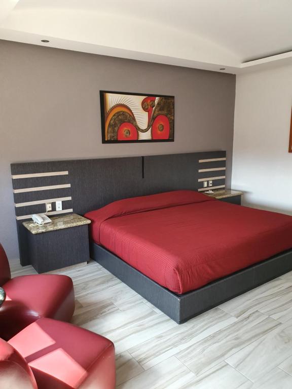 a bedroom with a red bed and a red chair at Hotel Tlahuac in Mexico City