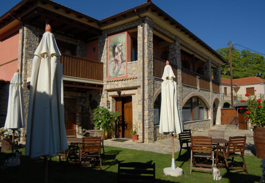 two closed umbrellas in front of a building at Guesthouse To Spiti Τou Gakou in Nestórion