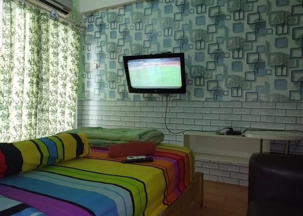 Schlafzimmer mit einem Bett und einem Flachbild-TV in der Unterkunft Apartmen Paragon Village by Taufiq in Tangerang