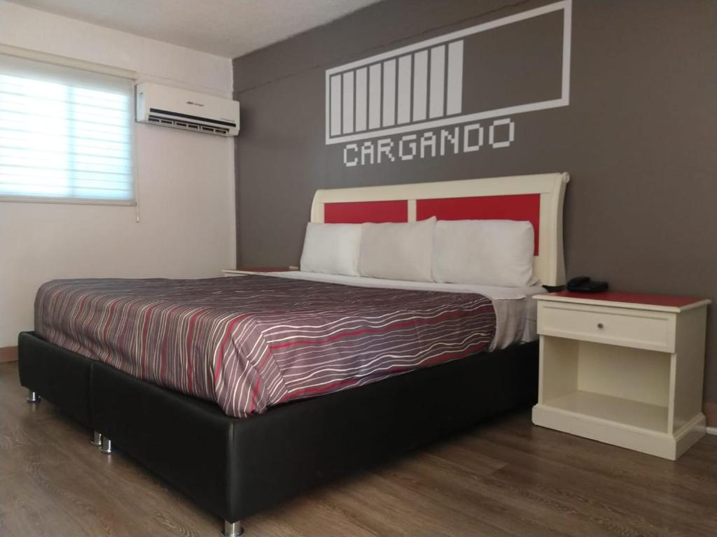 a bedroom with a large bed with a red headboard at Hotel Boulevard Mexicali in Mexicali