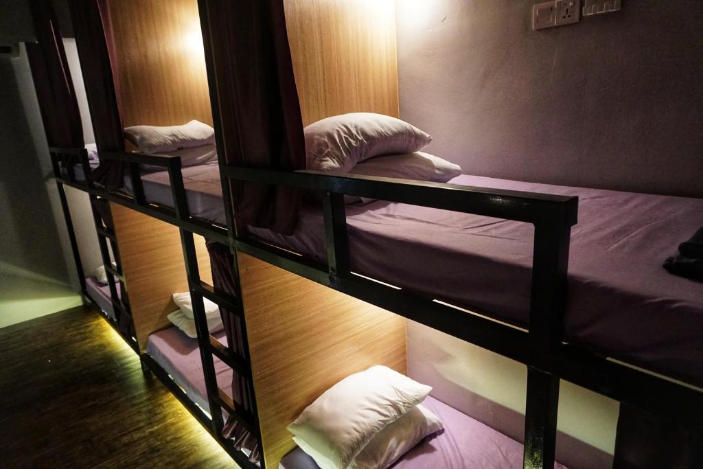 two bunk beds are in a room with at Wanderer In Melaka in Malacca