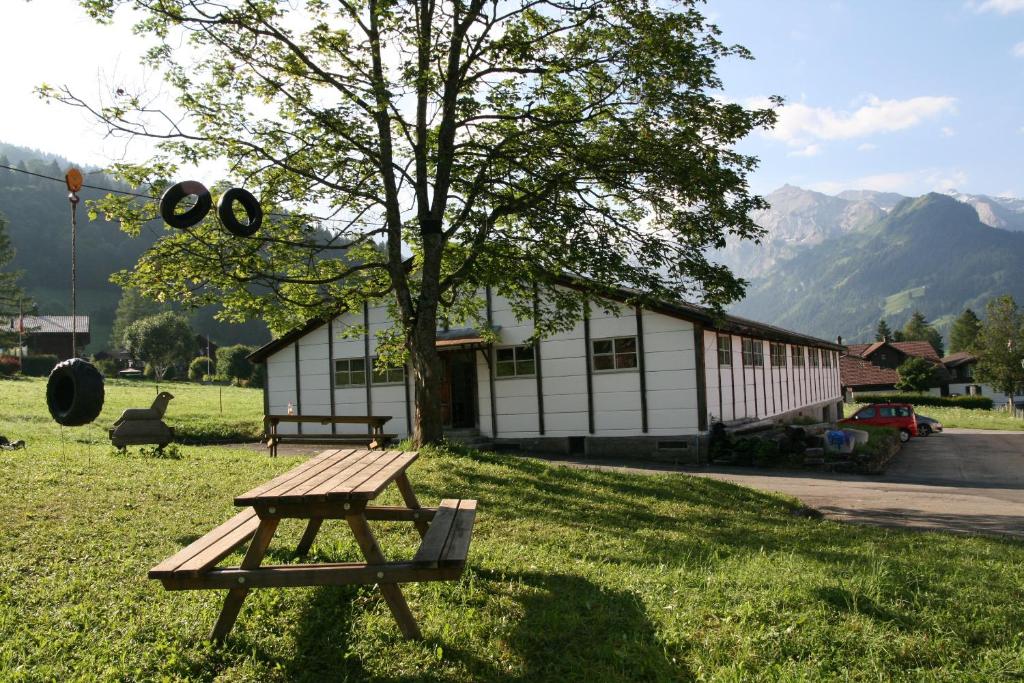倫克的住宿－Mountain Lodge Backpackercamp，坐在大楼前的草上野餐桌