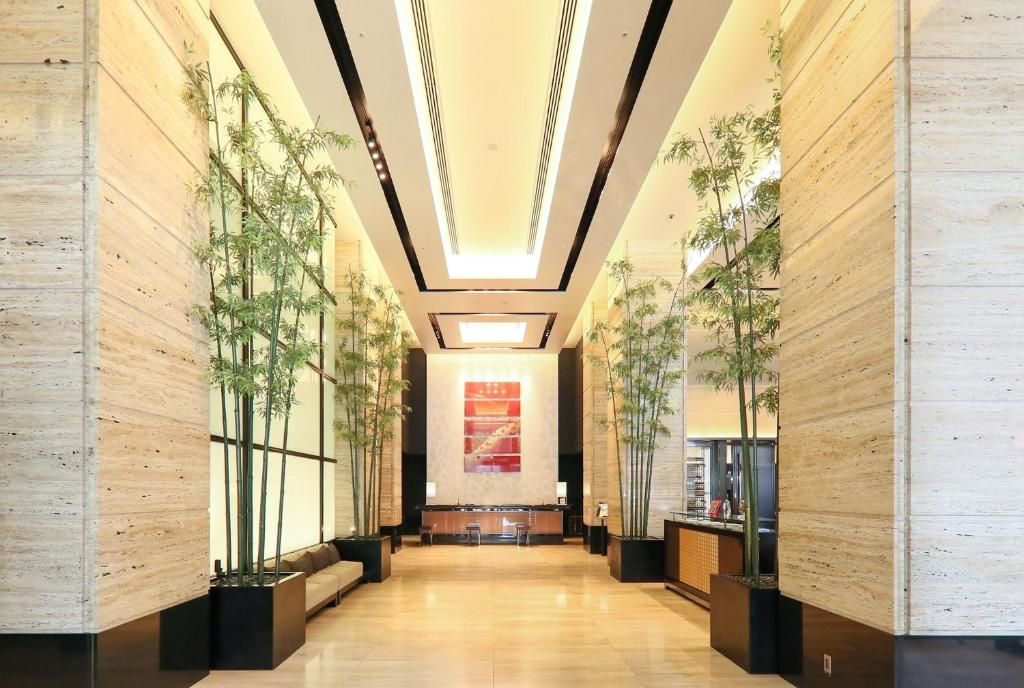 um corredor de um edifício com vasos de plantas em KOKO HOTEL Premier Kanazawa Korinbo em Kanazawa