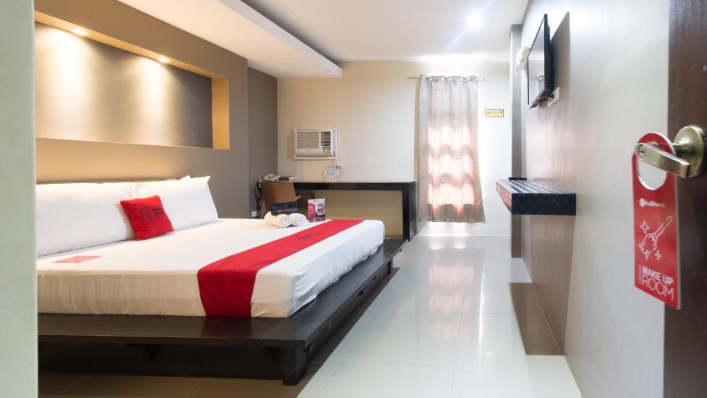 um quarto de hotel com uma cama e uma janela em Westgate Hotel em Laoag