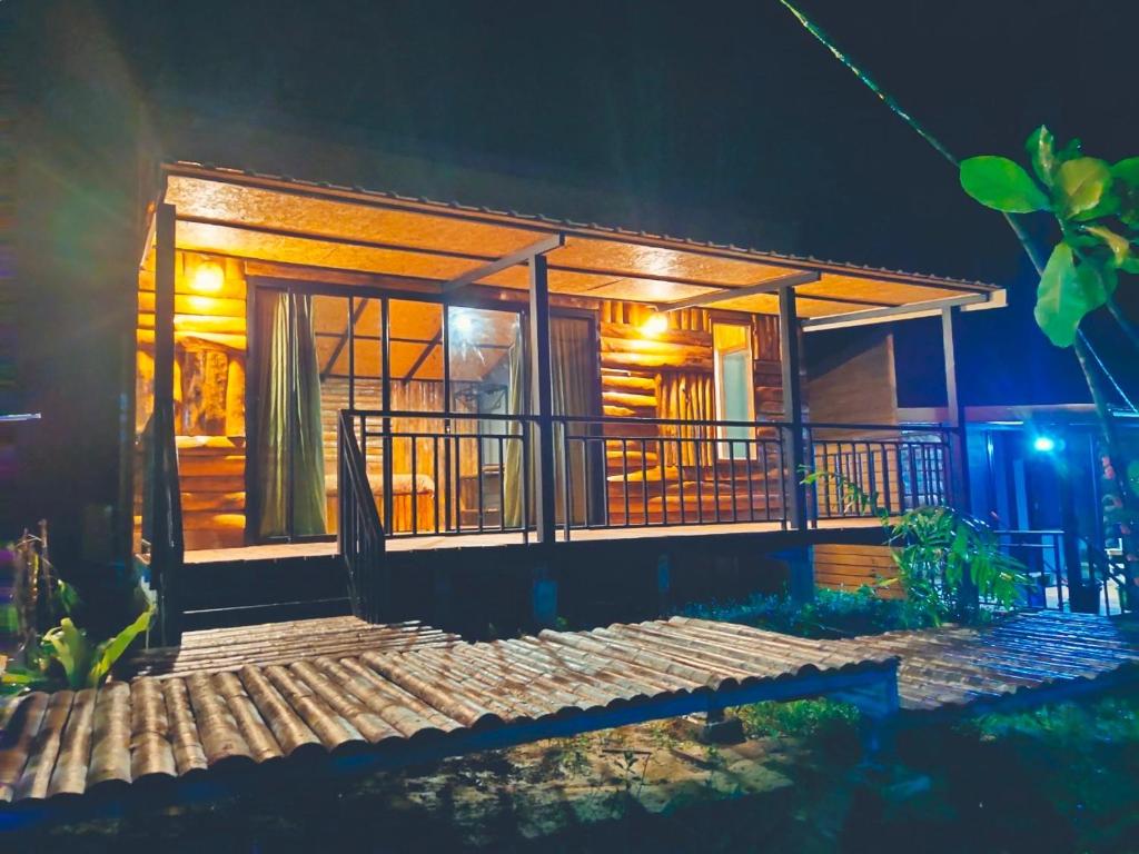 une maison en bois avec une terrasse couverte la nuit dans l'établissement Kohmook Nurse House, à Ko Muk