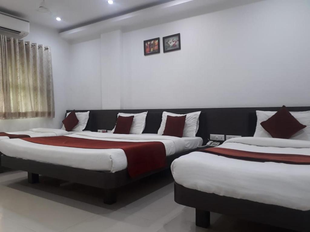 a bedroom with two beds in a room at HOTEL HARMONY in Vadodara