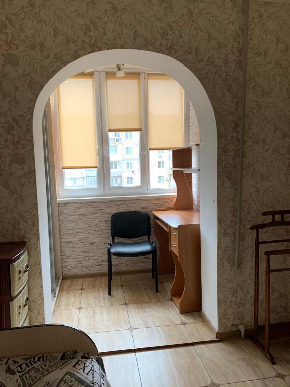 Zimmer mit einem Schreibtisch, einem Stuhl und einem Fenster in der Unterkunft 131 проспект Добровольского Хорошая 3-х комнатная квартира в Одессе in Odessa