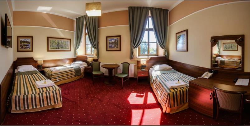 um quarto de hotel com duas camas e uma mesa em Browar Sulewski em Hrubieszów