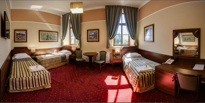 フルビエシュフにあるBrowar Sulewskiのベッド2台とテーブルが備わるホテルルームです。