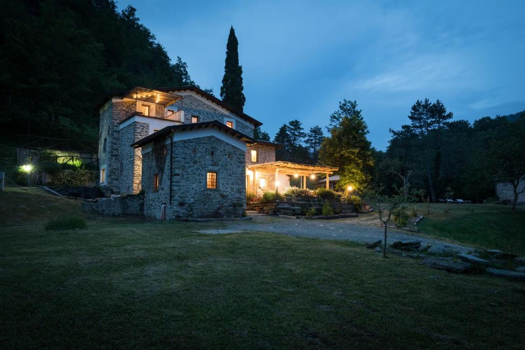 a large stone house with lights on it at night at Agriturismo di là dall'Acqua in Fivizzano