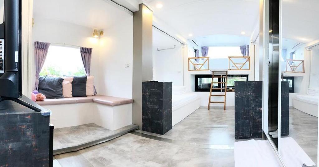 a living room with a bench and a window at Artisan Hostel in Toucheng