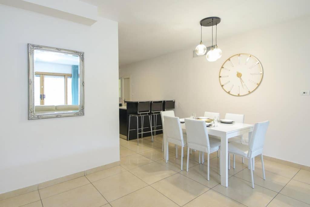 a dining room with a table and chairs and a clock at 107 - King David Residence - Jerusalem-Rent in Jerusalem