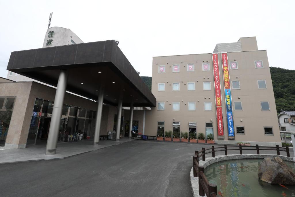 a large building with a pond in front of it at Kur and Hotel Isawa in Fuefuki