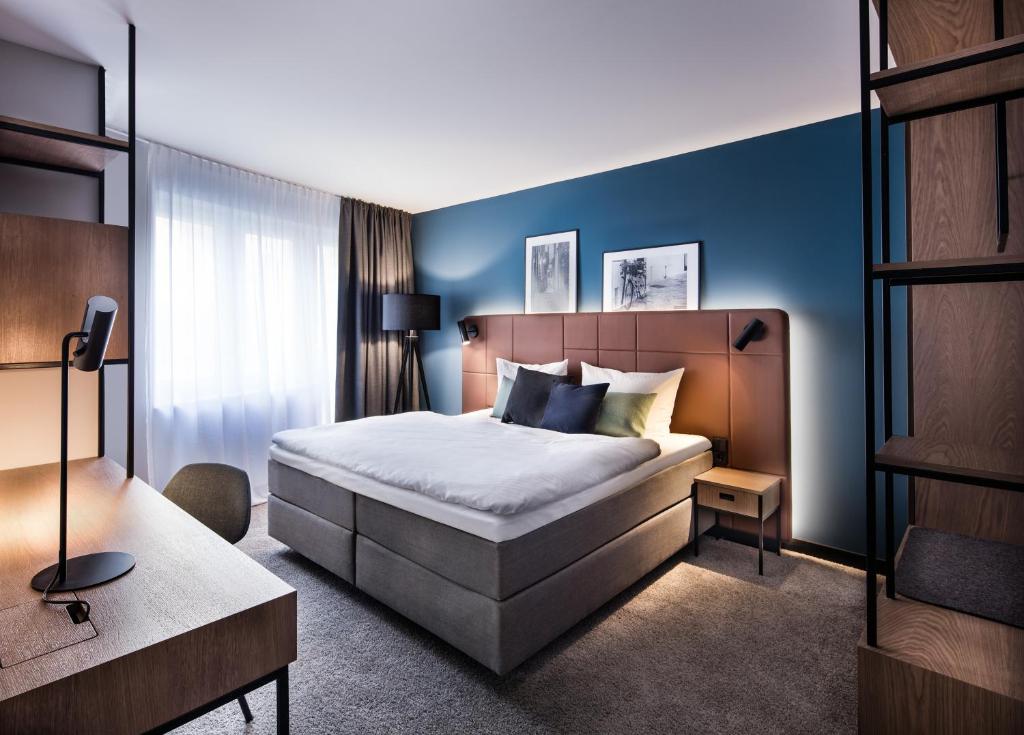 ein Schlafzimmer mit einem Bett und einer blauen Wand in der Unterkunft Domizil Tübingen in Tübingen