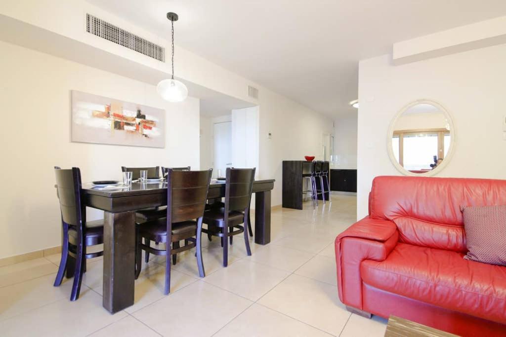 a living room with a red couch and a table at 108 - King David Residence - Jerusalem-Rent in Jerusalem
