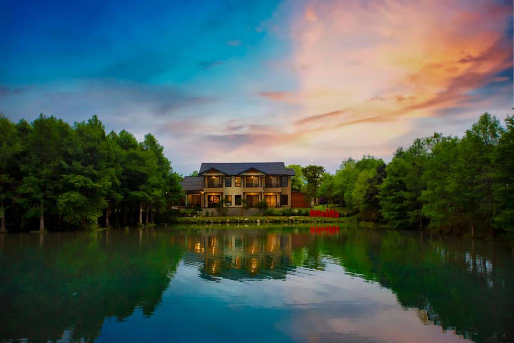 a house sitting on top of a large lake at Villa 88 in Fengping