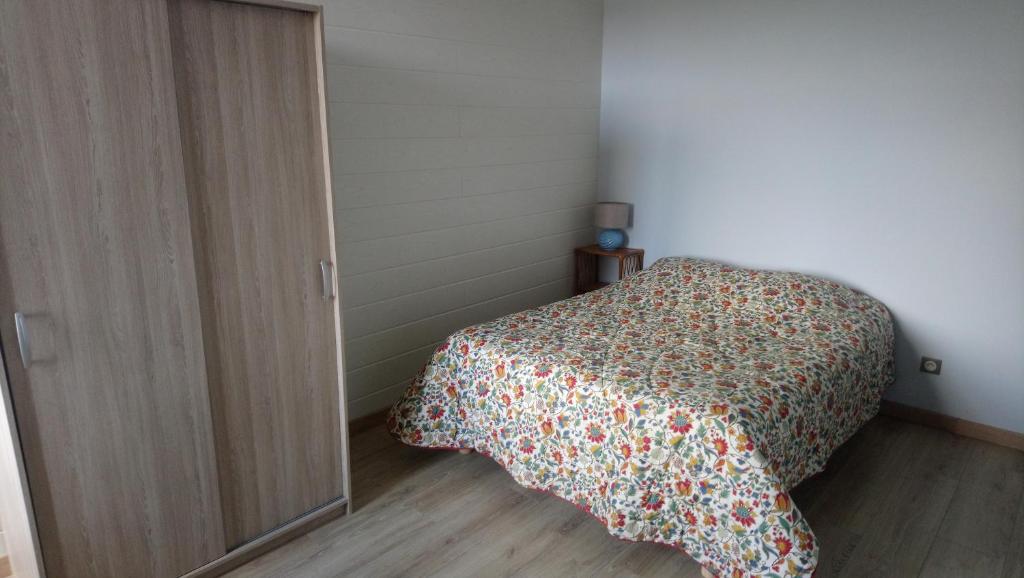 ein Schlafzimmer mit einem Bett mit einer Blumendecke in der Unterkunft Chambres d'Hôtes du Rupt in Euvezin
