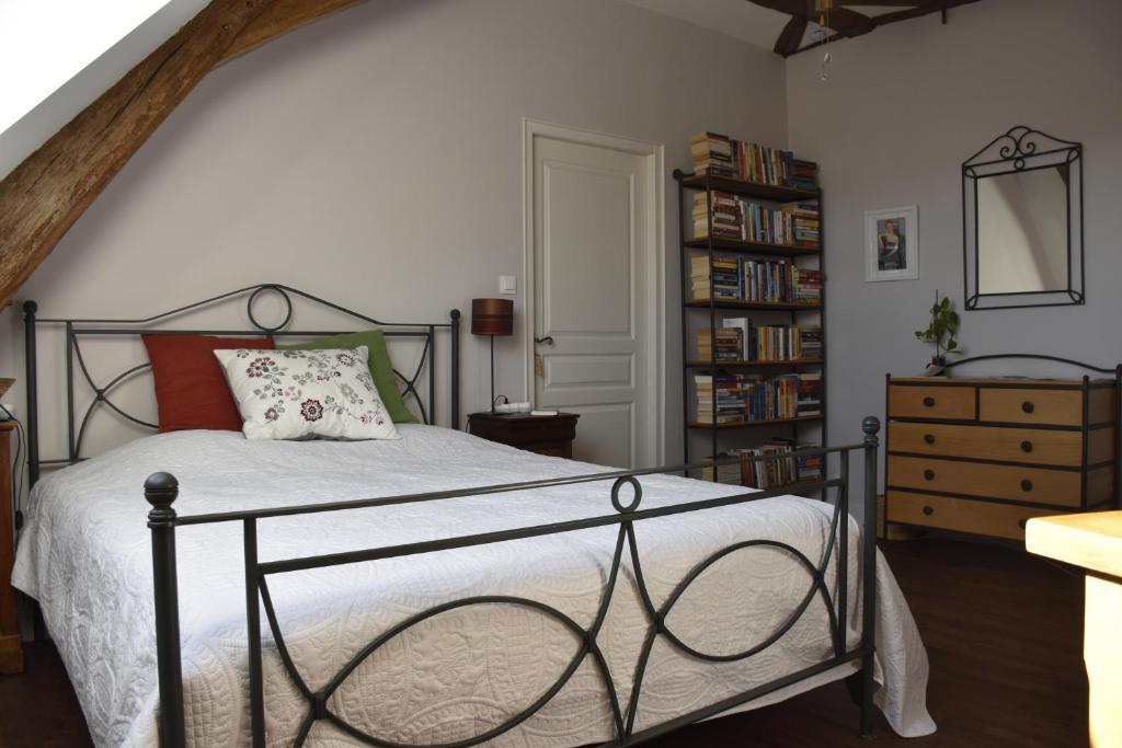 a bedroom with a bed and a book shelf at Jardin Secret in Moulins