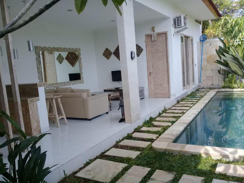 a villa with a swimming pool and a living room at Villa Blessings, 2 BR Villa near Lovina in Banjar