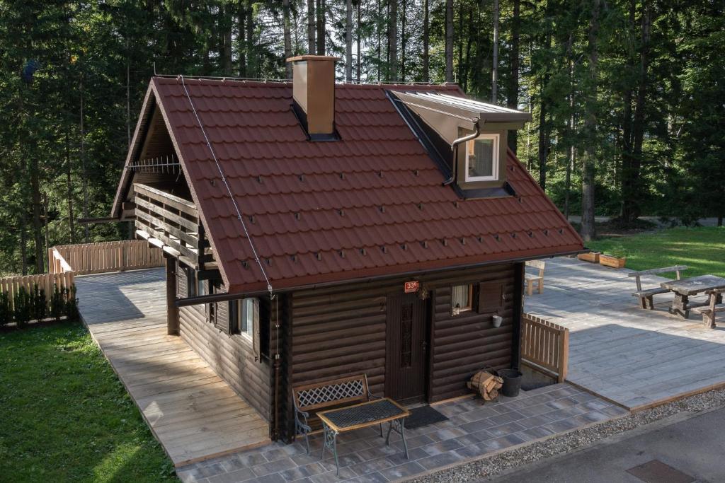 a small cabin with a red roof on a patio at Cabin Storzek in Hočko Pohorje