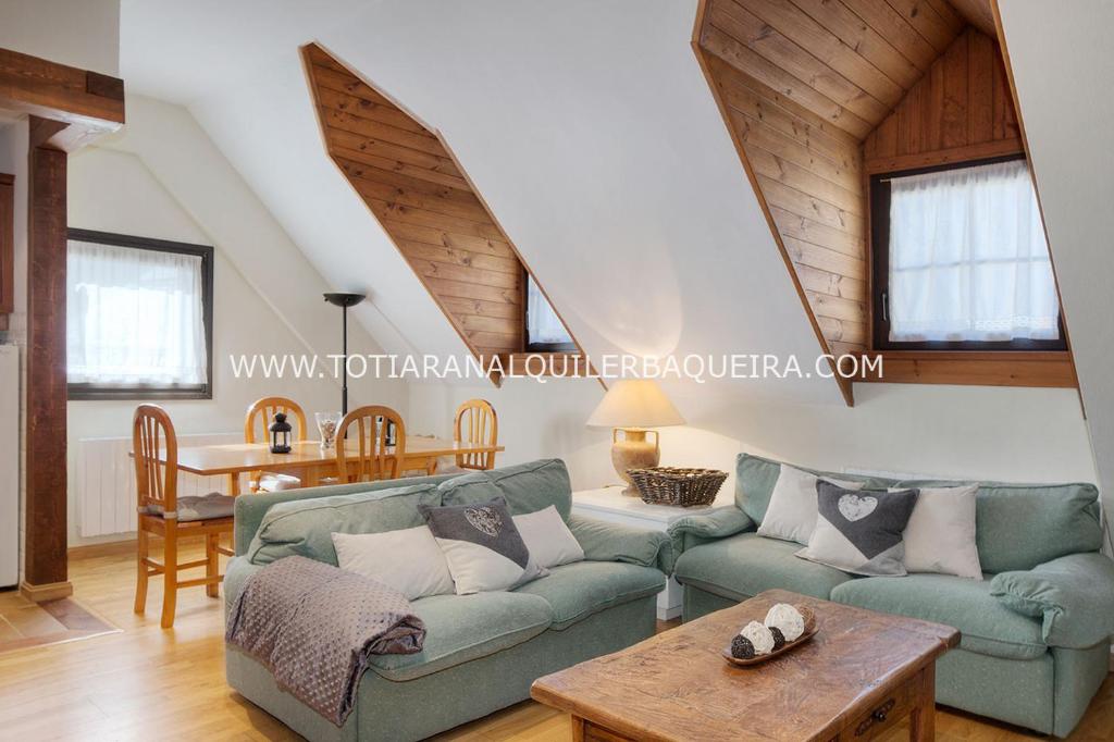 a living room with a green couch and a table at Torán by Totiaran in Baqueira-Beret