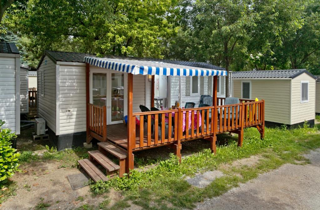 een klein huis met een terras met een veranda bij Albatross Mobile Homes on Camping Bella Italia in Peschiera del Garda