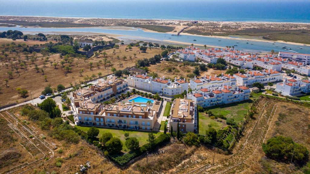 eine Luftansicht eines großen Hauses mit Strand in der Unterkunft Cabanas Gardens T2 Penthouse with Pool and fantastic views - WPCG19 in Cabanas de Tavira