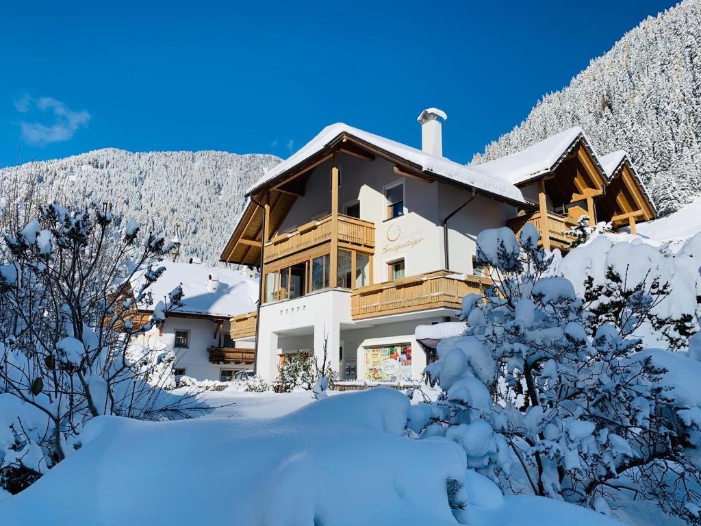 una casa en la nieve con árboles nevados en Apartments Grossgasteiger, en Rio Bianco