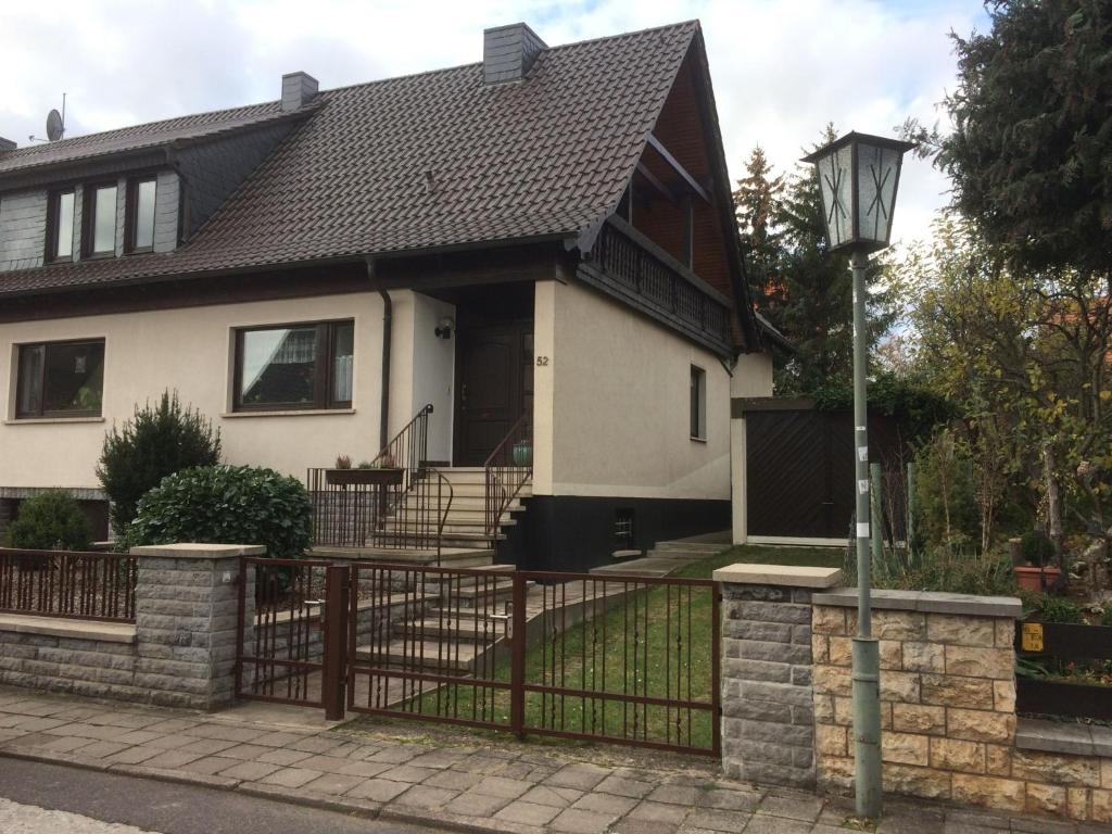 a white house with a fence and a street light at Gästezimmer Zoephel in Weimar