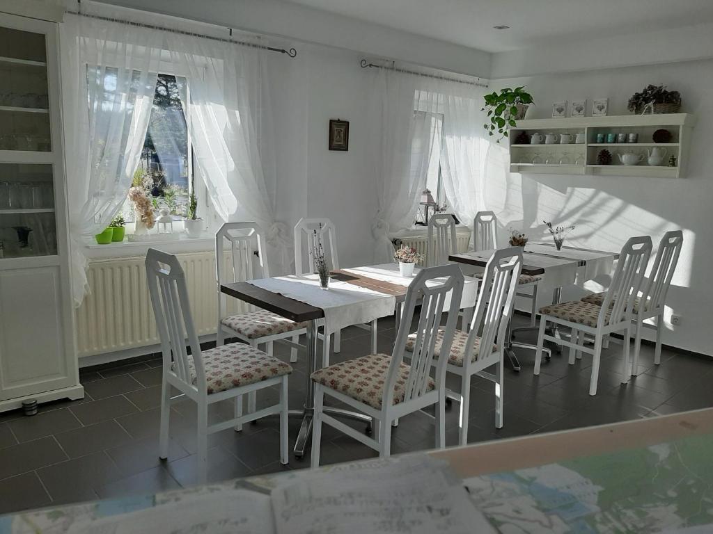 a white dining room with a table and chairs at Pension Mark in Hoyerswerda
