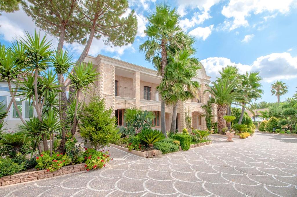 un bâtiment avec des palmiers en face de celui-ci dans l'établissement Maison Reale, à Foggia