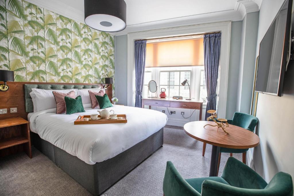 a bedroom with a bed and a table and chairs at Blackfriars in Inverness