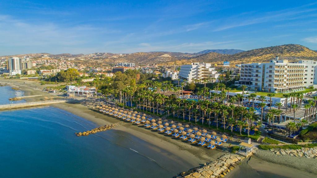 an aerial view of a beach with umbrellas and buildings at GrandResort by Leonardo Hotels in Limassol