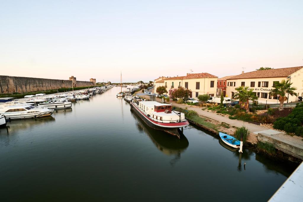 a group of boats are docked in a river at Maison des Croisades in Aigues-Mortes