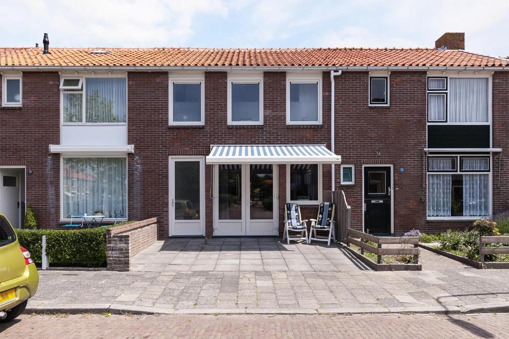 a brick house with a white awning and a patio at Studio's Westkapelle Willebrordstraat 13 in Westkapelle