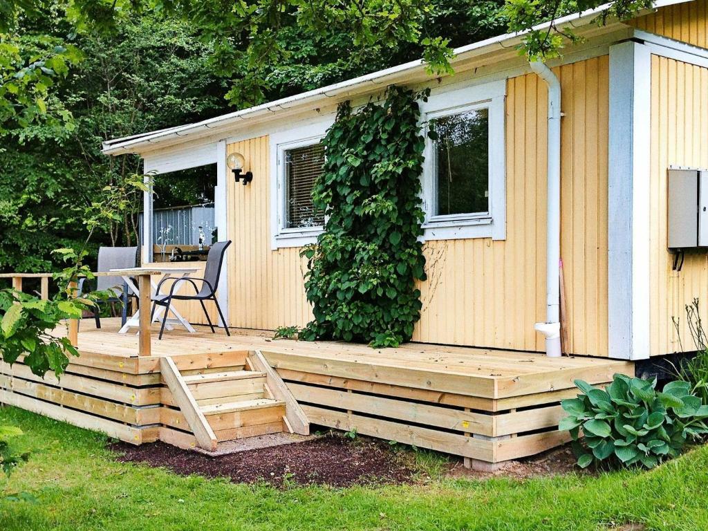 una casa con terraza de madera en el patio en Holiday home in Tyringe en Tyringe