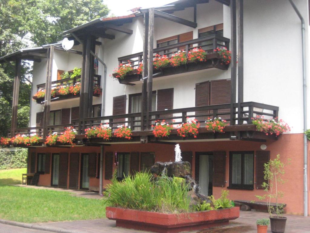 un bâtiment avec des fleurs sur les balcons et une fontaine dans l'établissement Auf dem roten Fels, à Eppenbrunn
