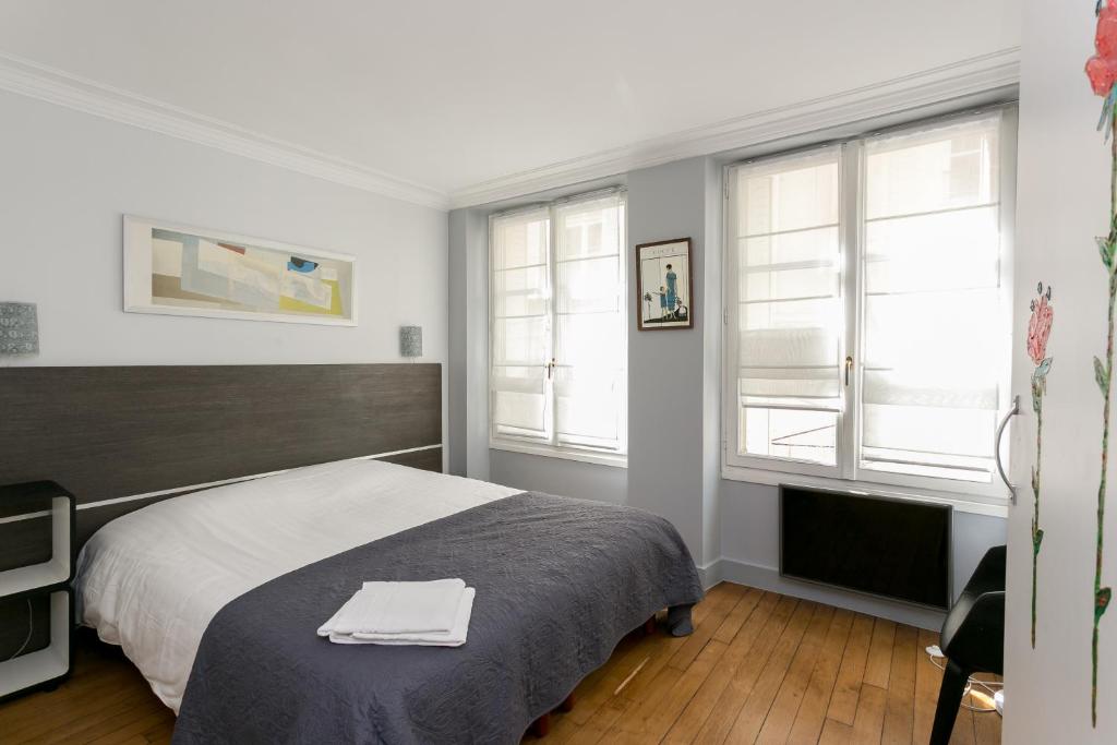 une chambre avec un lit avec deux serviettes dessus dans l'établissement Sourdiere Louvre Vendome with AC, à Paris