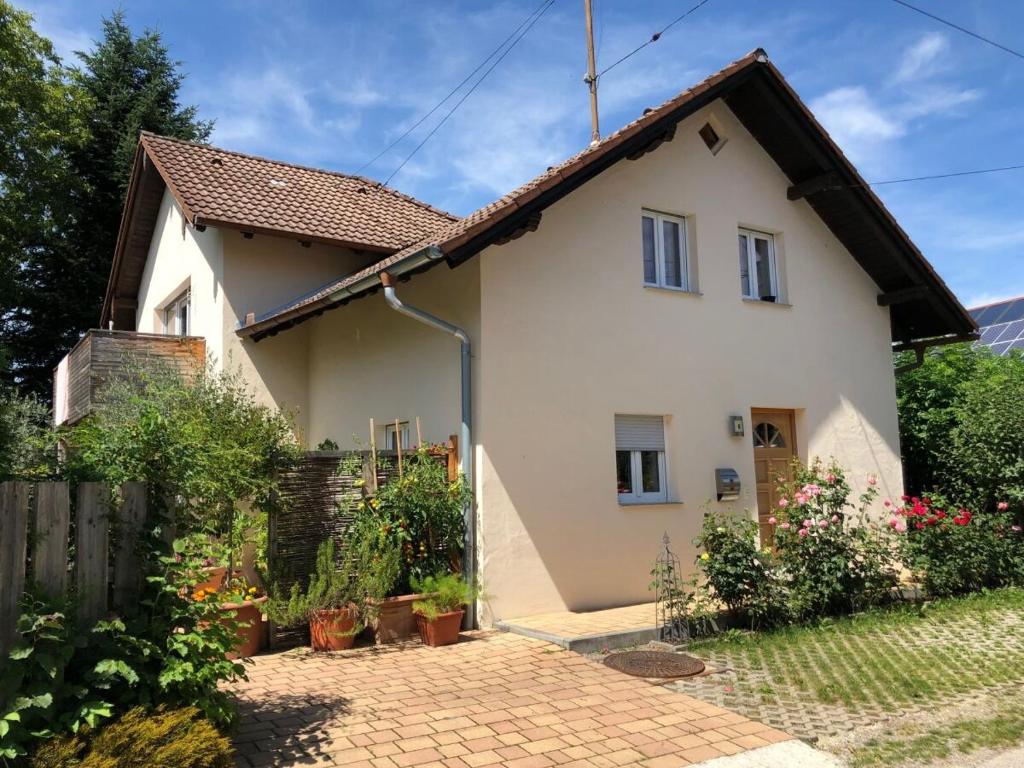 Casa blanca con valla y entrada de ladrillo en Ferienwohnung Lechraum in Waal, en Waal