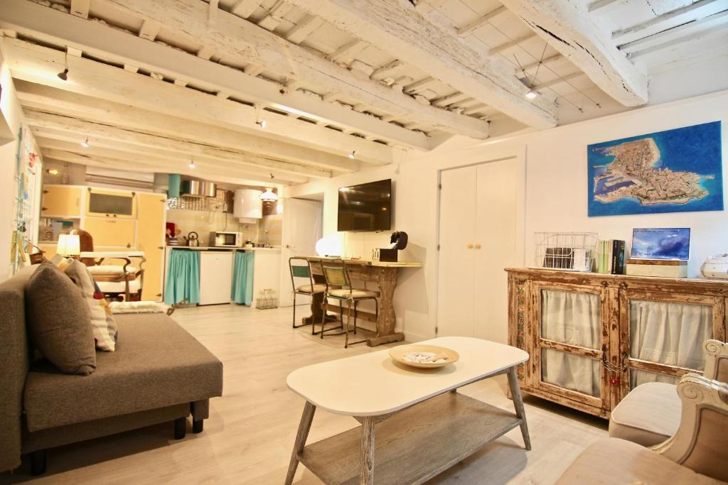 ein Wohnzimmer mit einem Sofa und einem Tisch in der Unterkunft Loft Rincon del Artista in Cádiz