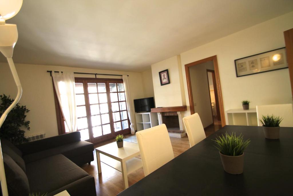 卡尼略的住宿－Ensagents, Canillo centro, Zona Grandvalira，客厅配有黑桌和白色椅子
