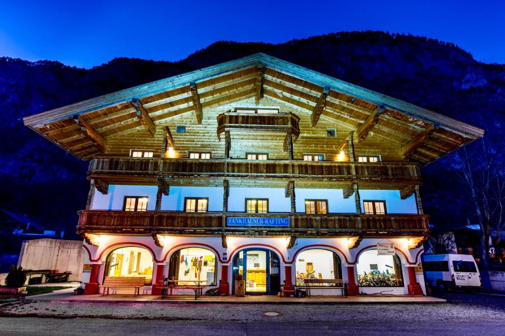 a large building with a balcony on top at night at Fankhauser OutdoorSport in Haiming