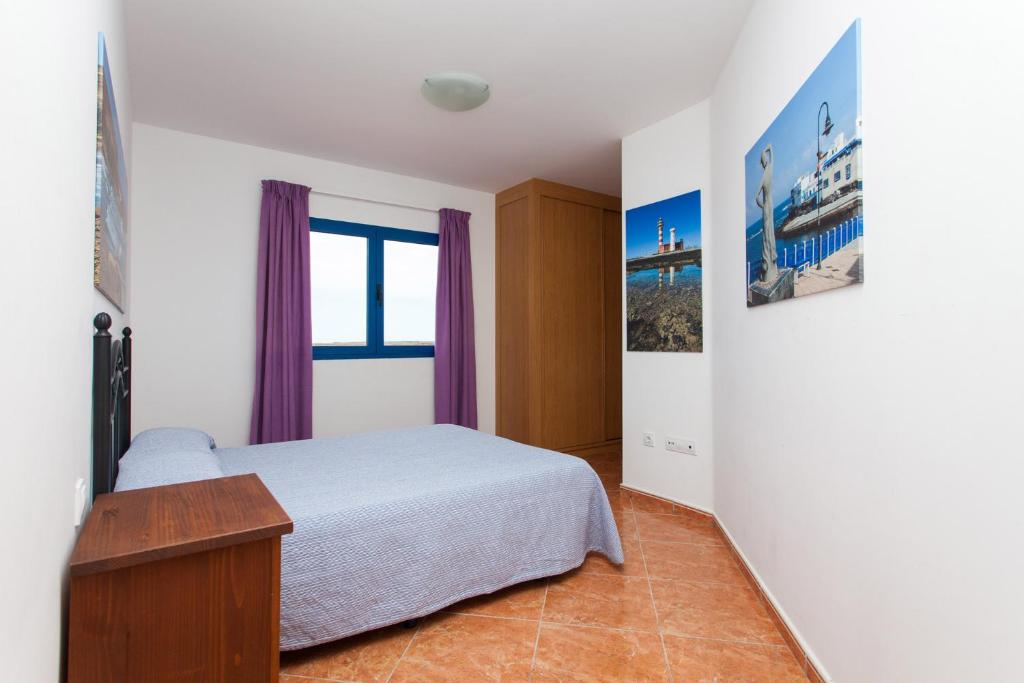 a bedroom with a bed and a window at TAO El Cotillo in El Cotillo