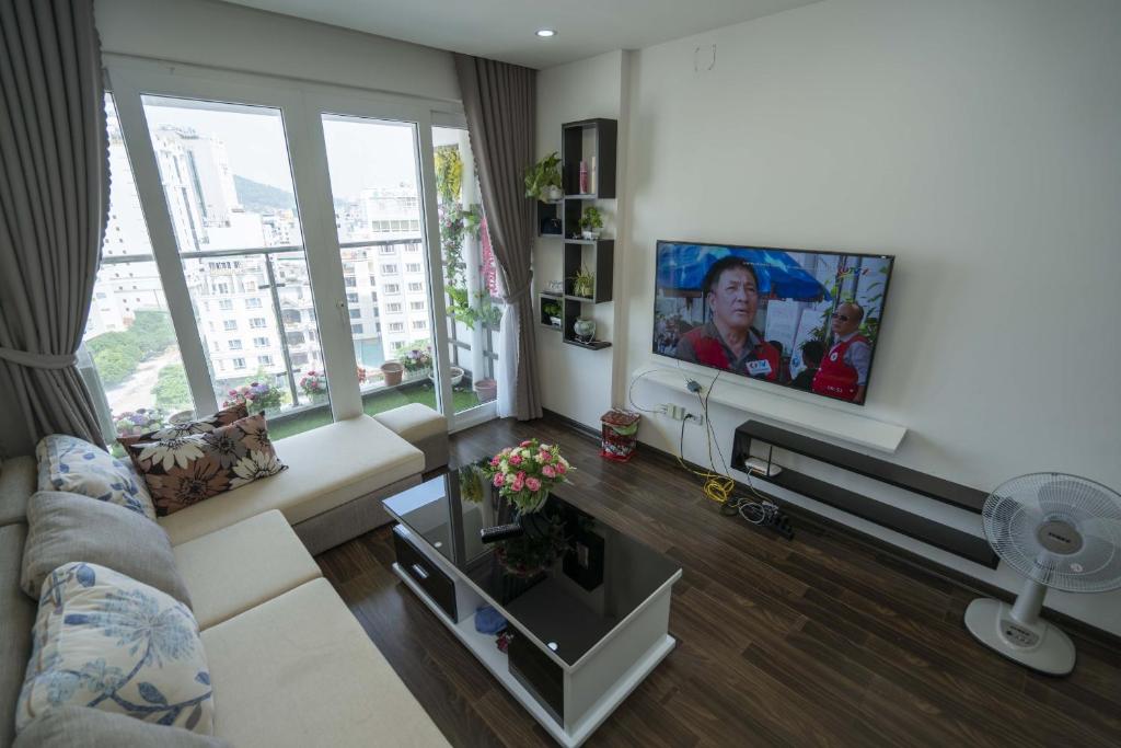 Una sala de estar con un televisor de pantalla plana en una pared. en Homestay sea view Newlife Halong., en Ha Long