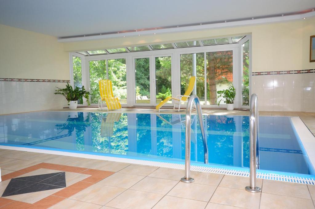a swimming pool in a house with a large window at Parkhotel Klüschenberg in Plau am See