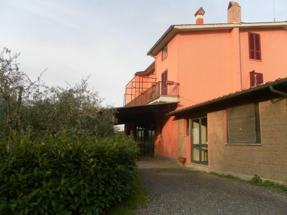 - un bâtiment orange avec un balcon sur le côté dans l'établissement IL CONTADO B&B, à Castel SantʼElia
