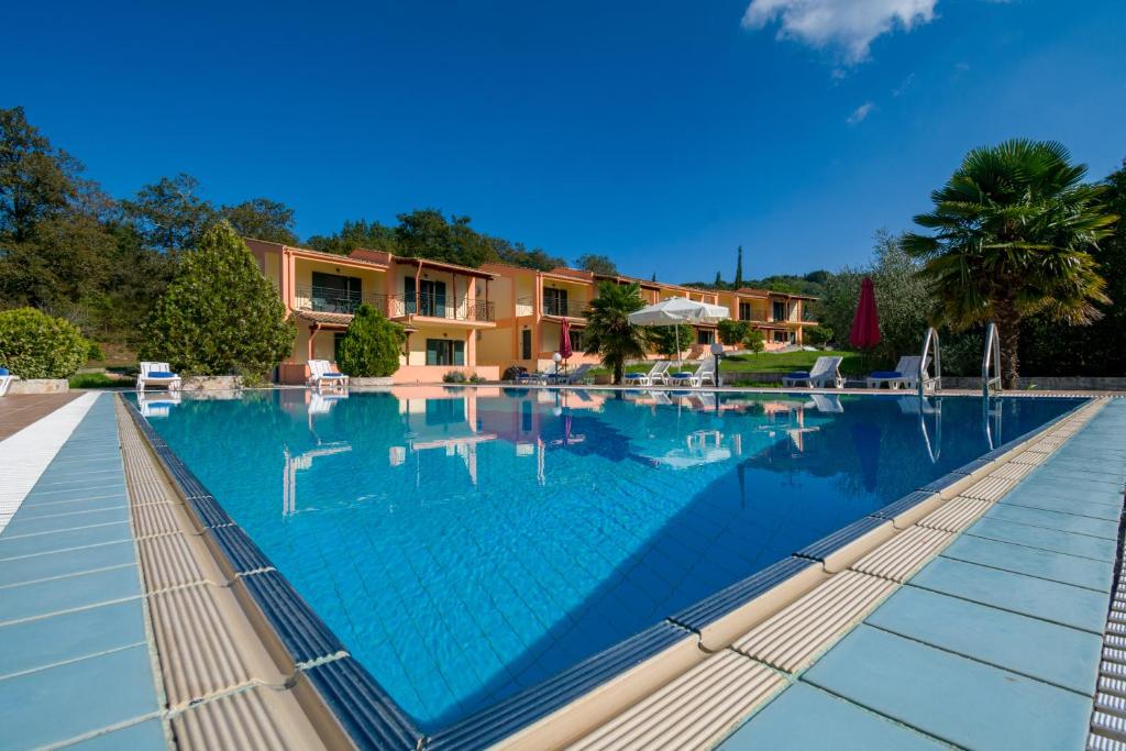 a large swimming pool in front of a house at Rivendell Apartments in Áno Korakiána